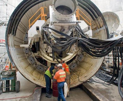 Workers next to tunnel boring machine