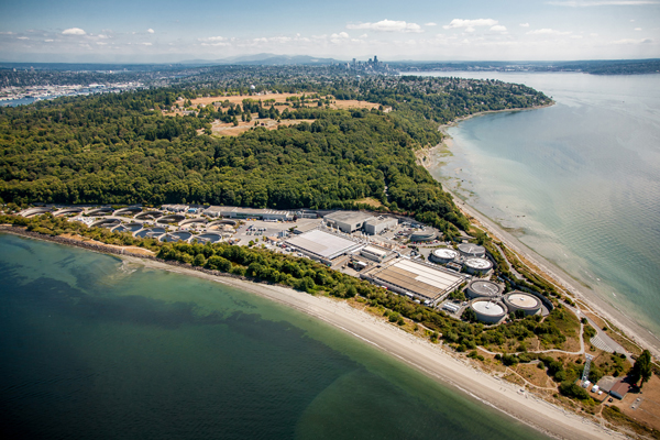 Aerial photo of the West Point Treatment Plant looking south with City of Seattle downtown in the distance