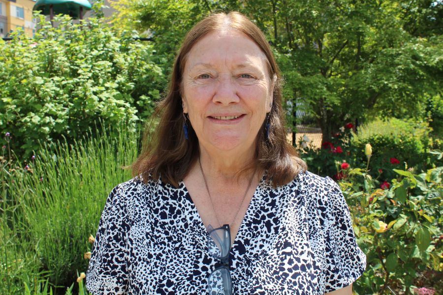 A photo of Tammy Himes, Haz Waste Business Services team, wearing a black and white patterned shirt and brown hair with a green grassy background
