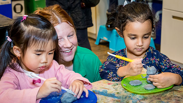 Children with teacher working on art projects.