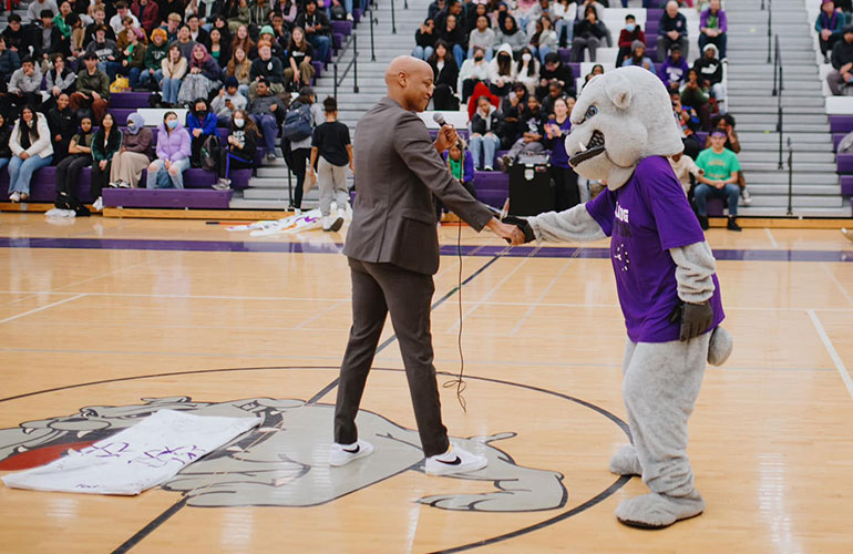 Councilmember Zahilay shakes hands with Garfield team mascot.