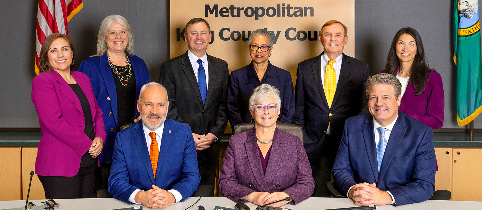 Group photo of all 9 King County Councilmembers behind the dias.