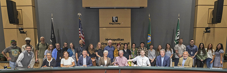 Group photo including councilmembers and others in the King County Council chambers.