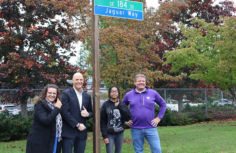 Councilmember Dunn stands with others under the new Jaguar Way street sign.