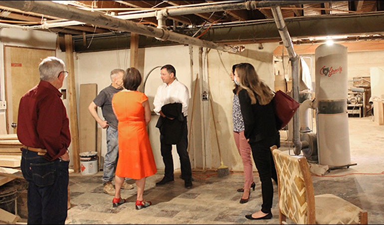 Councilmember Dembowski talks with small group in the basement of the Pioneer Woodworks building.
