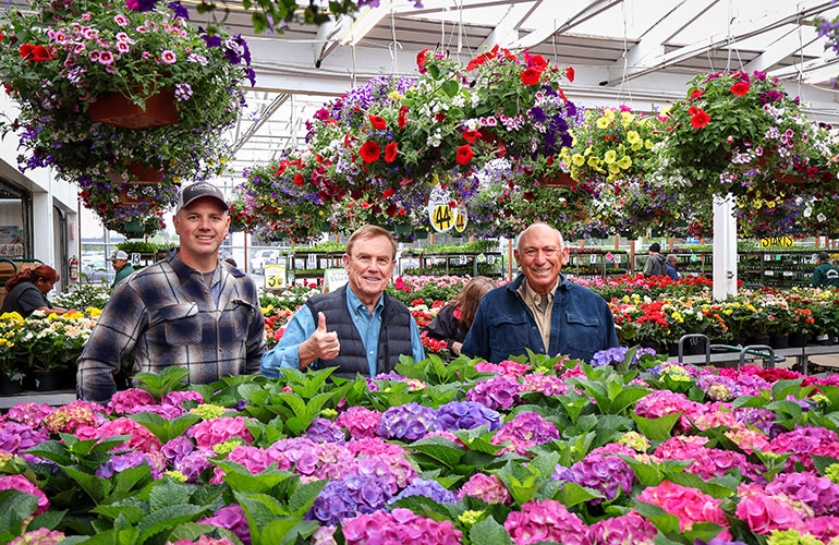 Posing behind a sea of flowers.