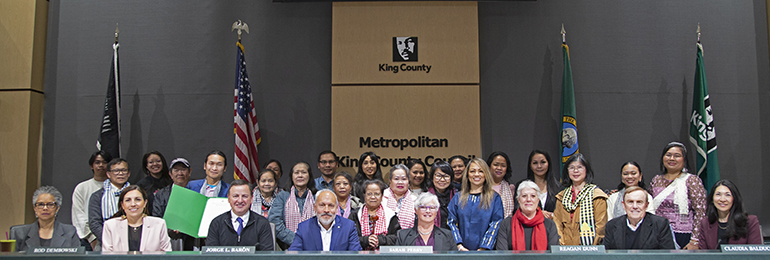 An image captured in the King County Council chambers, featuring community members alongside Councilmembers.