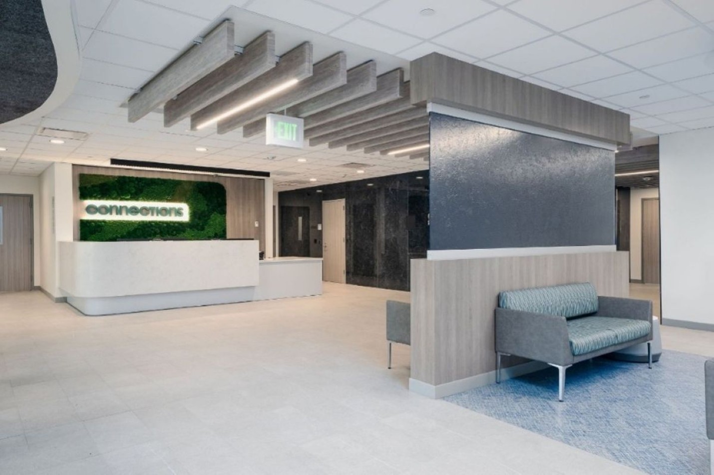 Photo of interior lobby of Connections Kirkland. It includes a seating area and reception desk, with a sign reading 