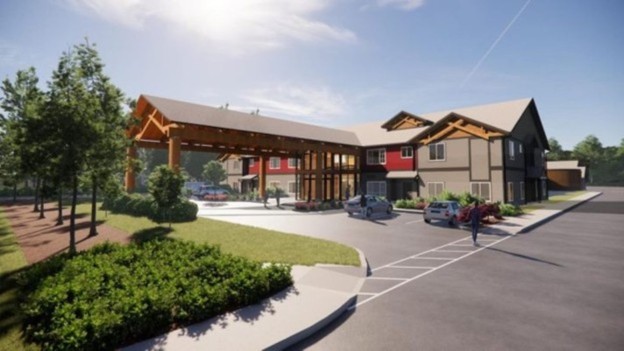 Computer generated image of the Thunderbird Treatment Center on Vashon Island. It is a two story light brown building with a parking plot, landscaped with grass and trees.