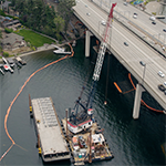 Barges and crane installing new sewer pipe under Lake Washington at I-90