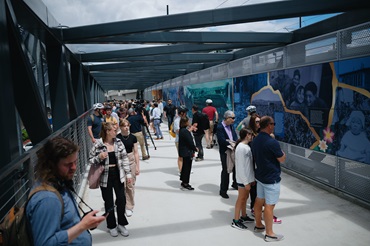 Pedestrians walk on new Wilburton Station bridge