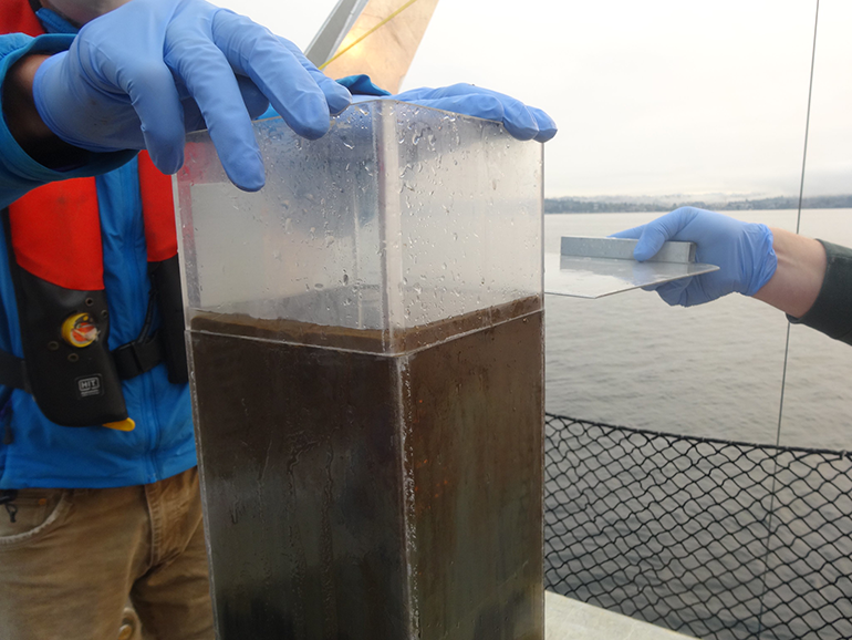 Researchers aboard King County’s research vessel, SoundGuardian, collect a sample from the core of Lake Washington
