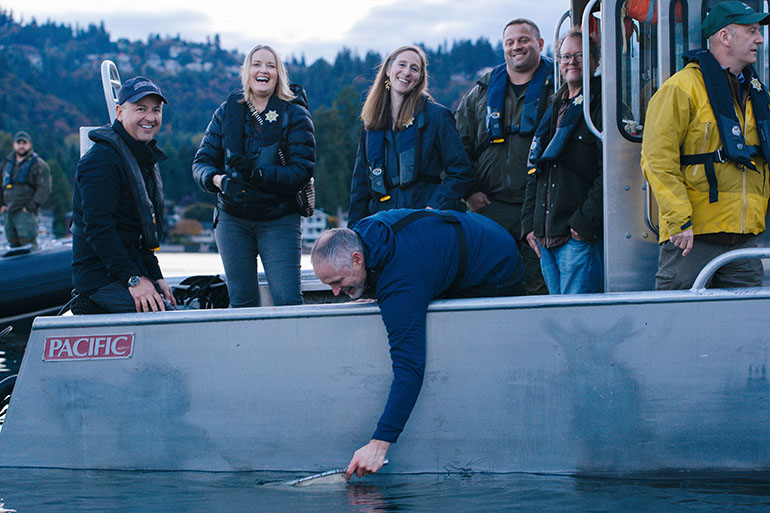 King County Deputy Executive and County Councilmember Rod Dembowski release kokanee from a boat near the middle of Lake Sammamish.