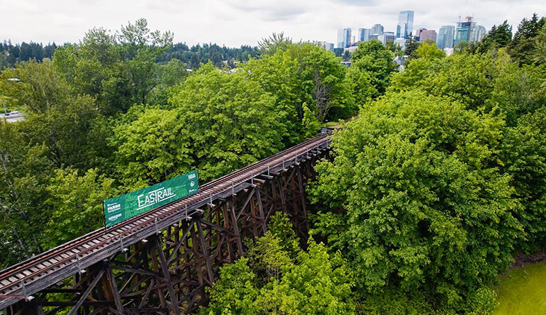 Wilburton Trestle on Eastrail with forest and City of Bellevue in the distance