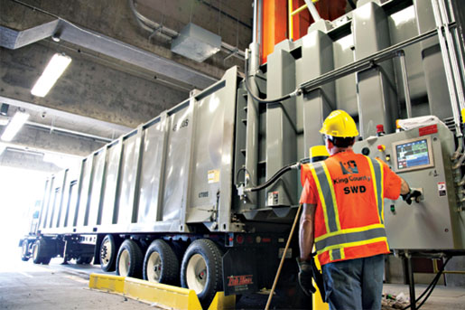 Operator using the waste compactor at a transfer station