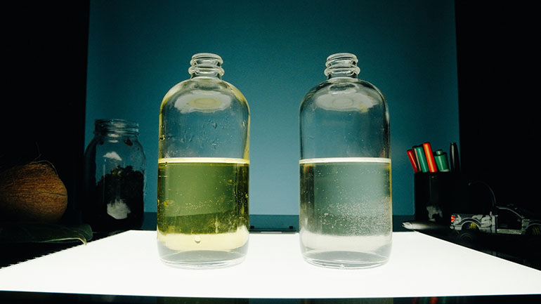 Comparison of water samples with bottle of yellow water next to bottle of clear water