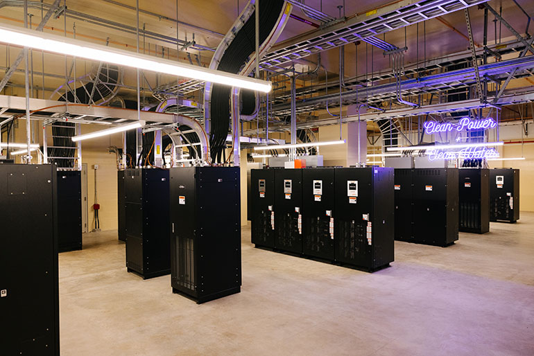 West Point Treatment Plant backup batteries with neon sign: Clean Power Clean Water