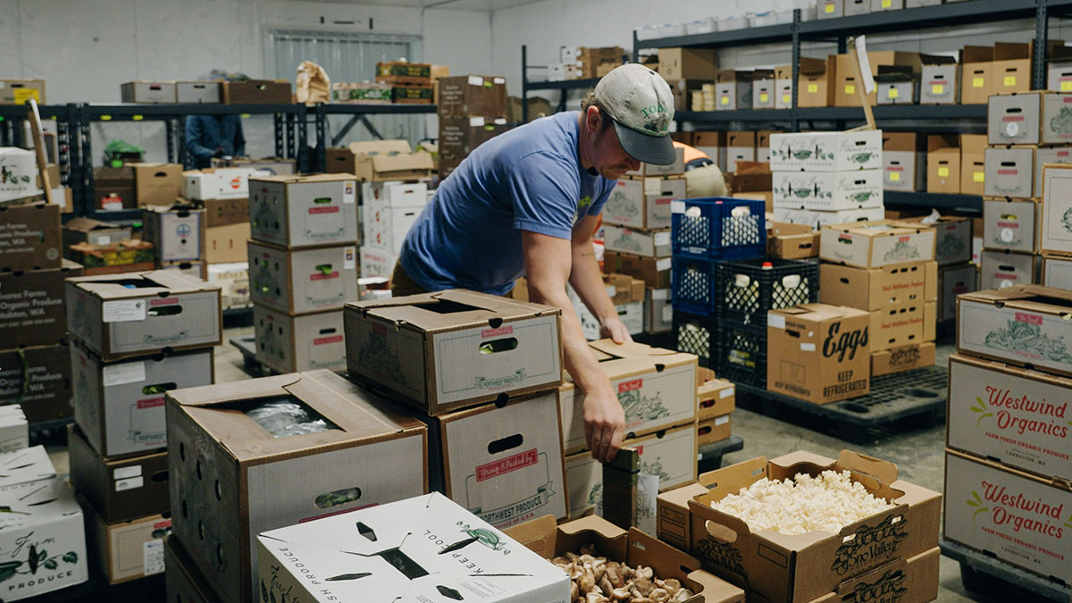 Farmstand Local Foods workers organizing boxes of produce