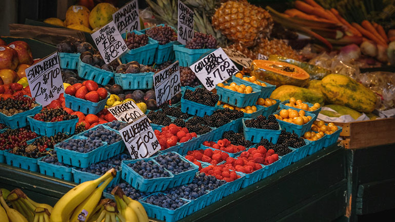 Fruit stand with strawberries and blueberries along with tropical fruit