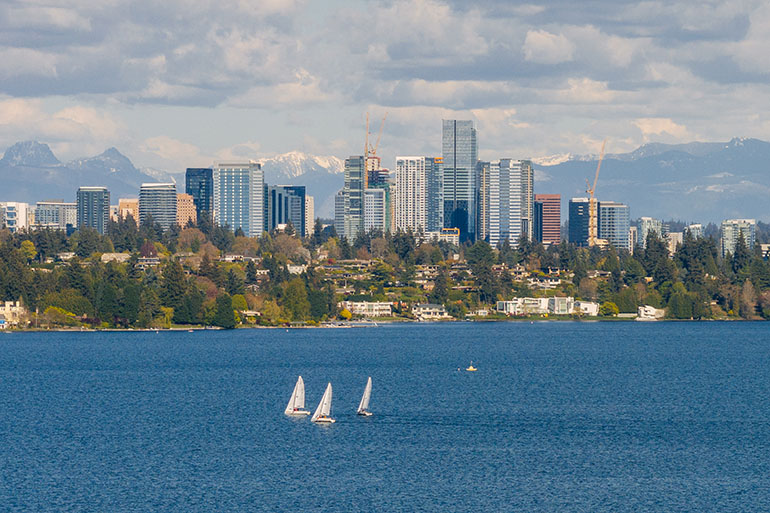 Sailboats on bright blue Lake Washington with Bellevue skyline in the background
