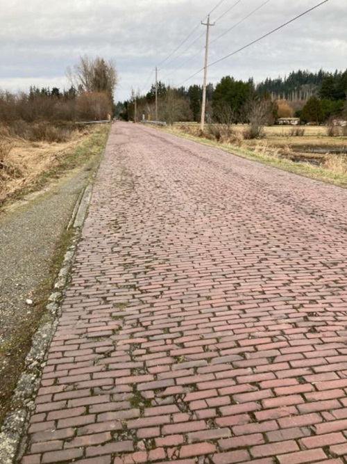 Surfaced with locally made red brick in 1913, the roughly 1-mile long Red Brick Road (aka Mattson Road) outside Redmond is the longest exposed stretch of red brick road left in King County. It once served as a segment of the historic Yellowstone Trail, the first transcontinental auto route from Boston to Seattle. 