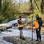 Surveyors working in Coal Creek on a sewer project