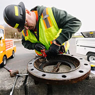 Wastewater treatment system worker grinding a flange
