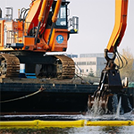 Bucket digger removing polluted sediment