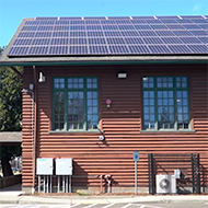 Log cabin at Steve Cox Memorial Park with solar panels and electric services