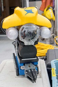 A yellow and blue ROV (remotely operated vehicle) sits on a white topped cooler on the rear deck of R/V SoundGuardian.