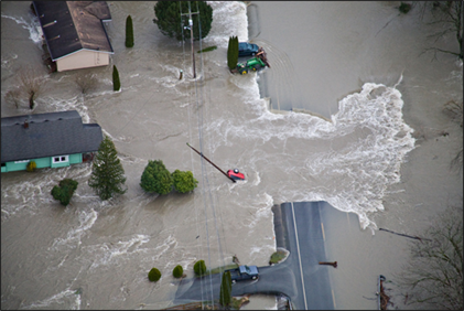 Aerial view of a road and two homes being flooded