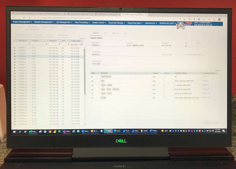 An open laptop computer sits on a dark colored counter. The screen shows environmental sampling data that are displayed using the laboratory information management system (LIMS).  