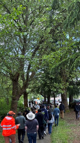 People walking on a paved trail under trees.