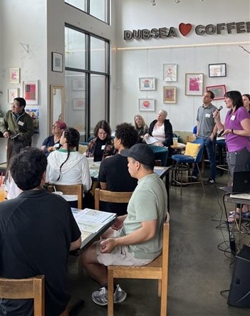 People listening to a presenter at an open house at Dubsea Coffee. 
