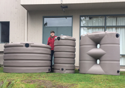 Two happy rainwater harvesters hugging a cistern