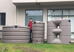 Two happy rainwater harvesters hugging a cistern
