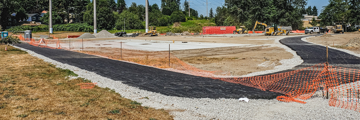 A new asphalt path winds through construction of Skyway Park