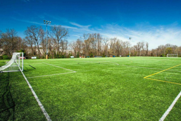 Large turf soccer field with goals on a bright sunny day.