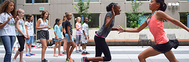 Two children tag during a relay race as others watch