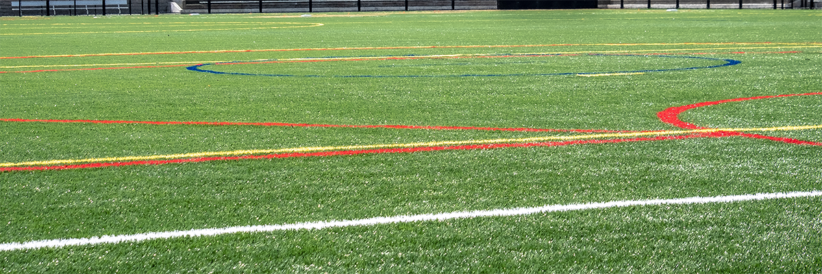 A turf ball field lined for multiple sports in different colors