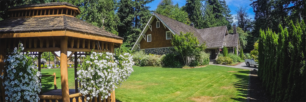 A gazebo with hanging white flowers and the Jim Ellis Community Center