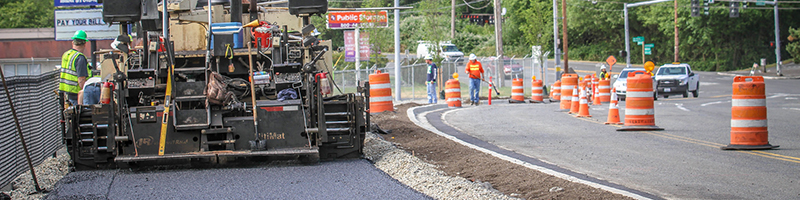 An asphalt paver lays down a section of the trail in Burien