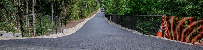 A steam roller flattens out new pavement on a section of the Lake to Sound Trail