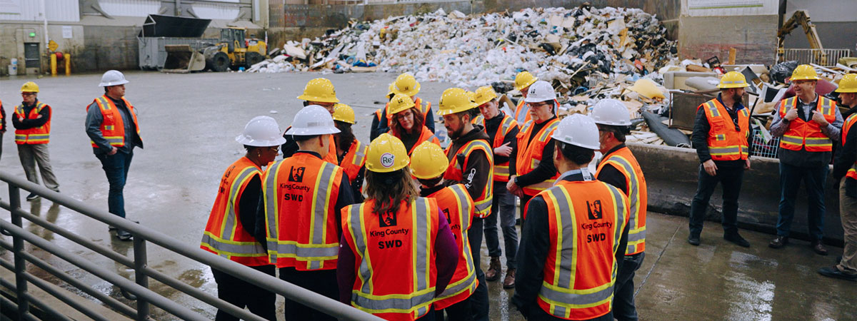 King County Solid Waste Division employees wearing orange vests while attending a safety meeting at the Factoria Recycling & Transfer Station