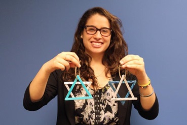Girl holding two Star of David popsicle stick Hanukkah decorations