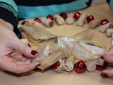 Making a holiday wreath from wine corks and jingle bells