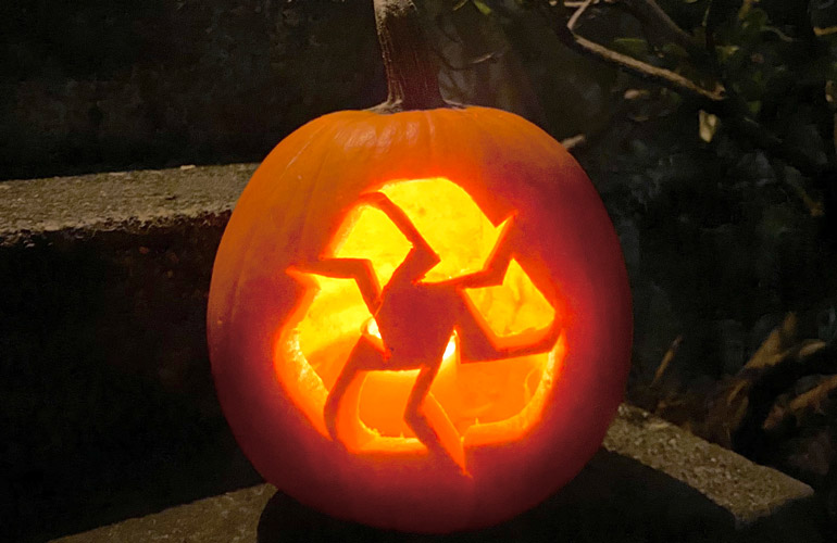 Image of a jack-o-lantern carved with a chasing-arrows recycling symbol