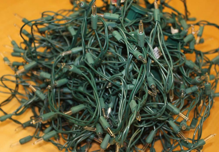 A string of holiday lights on an orange background