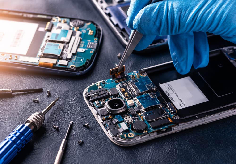 close-up image of rubber-gloved hands repairing a smartphone - links to the Repair businesses page of the King County EcoConsumer website