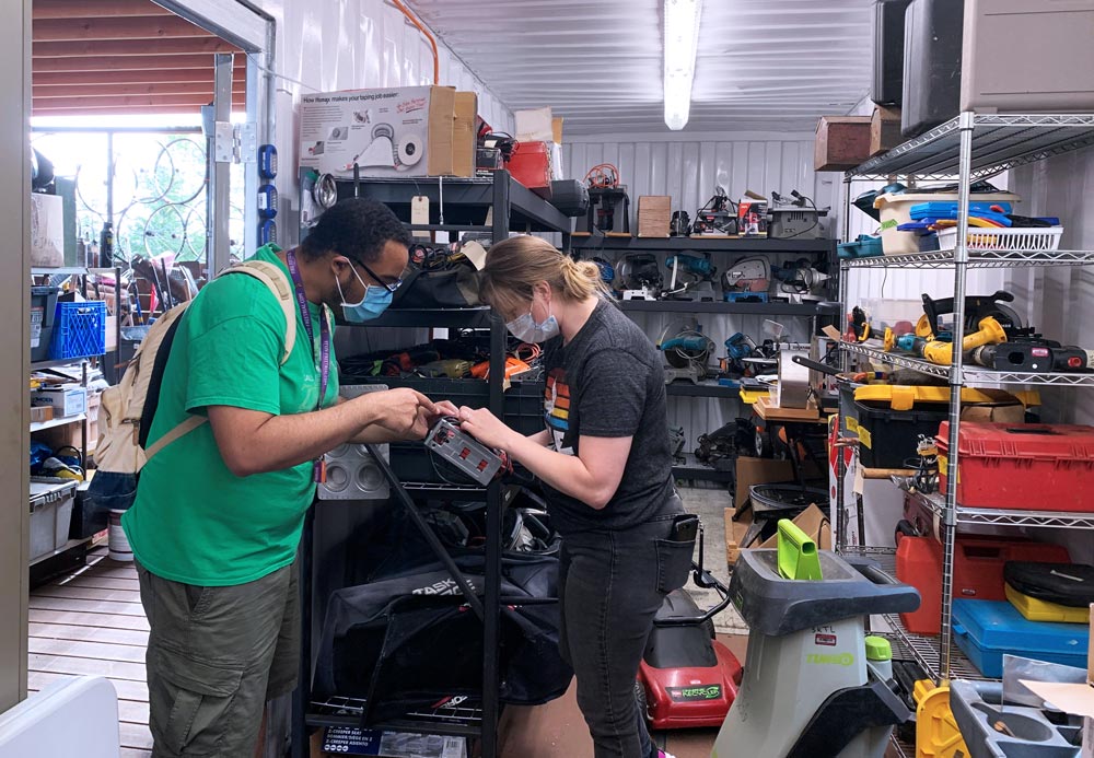 image of an employee and a customer examining a tool in a tool-lending facility - links to the Tool libraries page of the King County EcoConsumer website